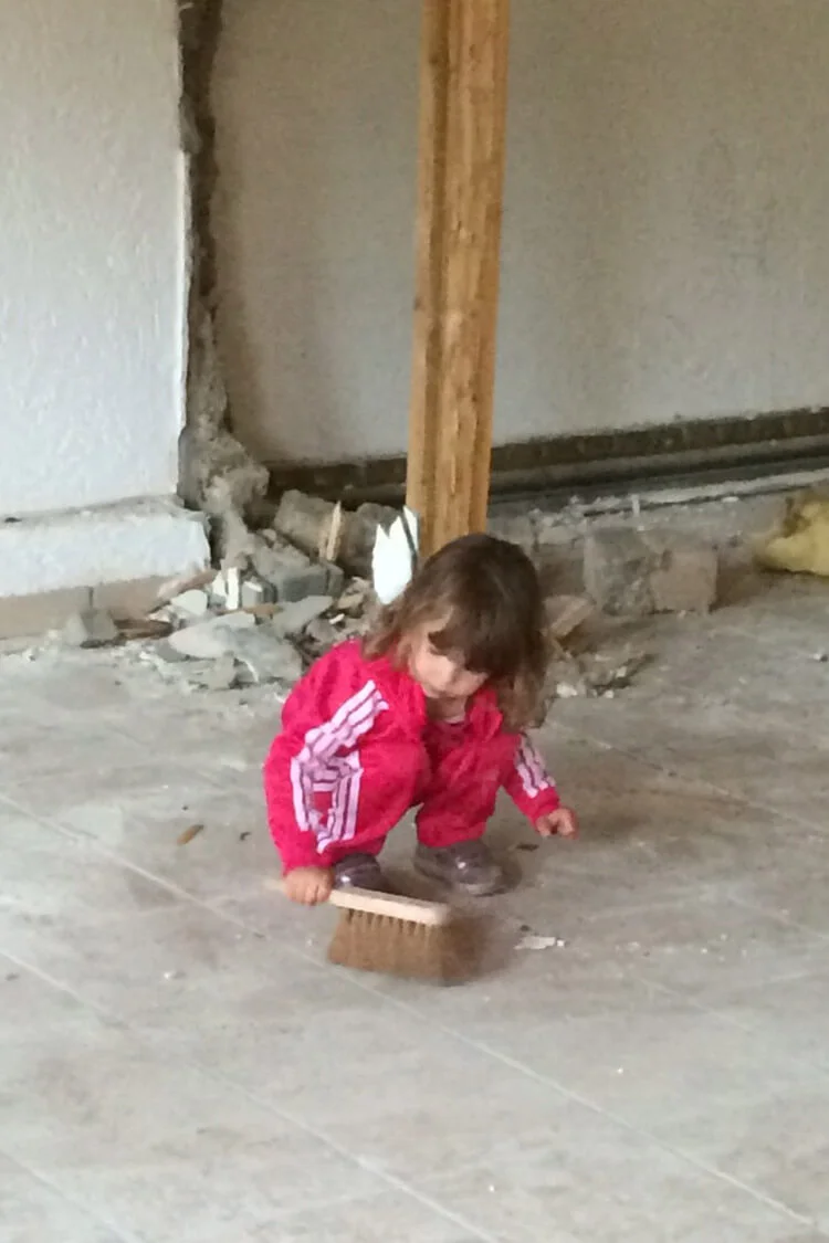 Auch die Kleinsten halfen mit: ein kleines Mädchen fegte den Dreck auf dem Boden zusammen Auch die Kleinsten halfen mit: ein kleines Mädchen fegte den Dreck auf dem Boden zusammen