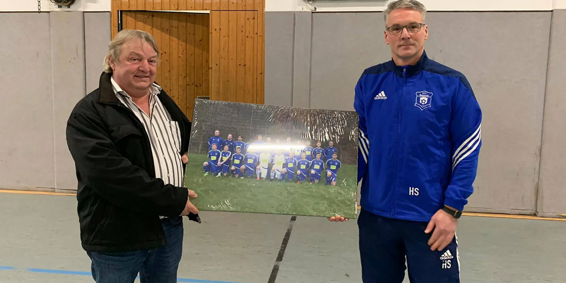 Trainer Holger Schulte (r.) und Sponsor Rüdiger Reidl (l.) bei der Übergabe eines Bilds der Mannschaft